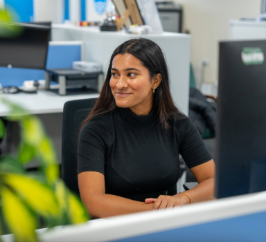 A Thames Water apprentice smiling while working in the office