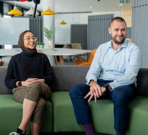 two colleagues smile and have a conversation