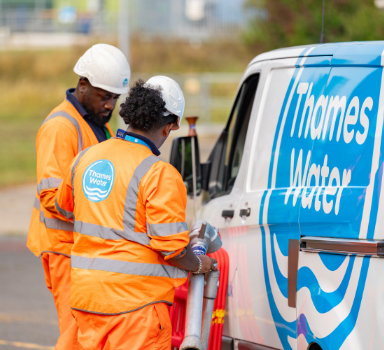 two network service technicians standing next to a Thames Water van