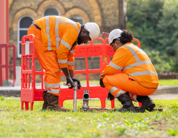 two network service technicians at work detecting a leak